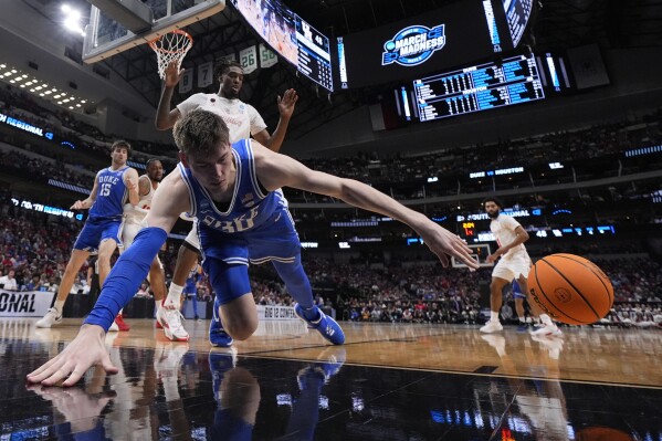 Duke player fell on to the floor while he was trying to make a goal against Houston.