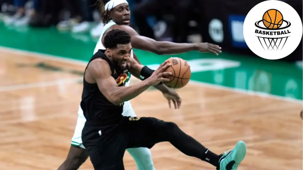 Cleveland Cavaliers guard Donovan Mitchell, front, grabs a rebound next to Boston Celtics guard Jrue Holiday during the first half of Game 1 of an NBA basketball second-round playoff series Tuesday, May 7, 2024, in Boston.