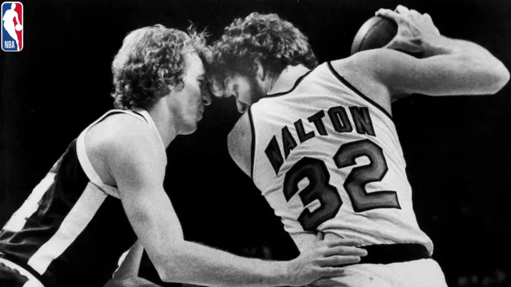 In a game between the Denver Nuggets and the Portland Trail Blazers in Portland, Oregon, on February 12, 1978, Dan Issel of the Nuggets is seen guarding Bill Walton of the Trail Blazers as Walton drives towards the basket.