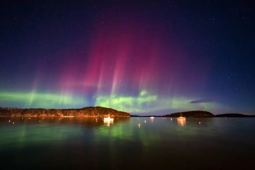 Angie Avitia, left, and Marshall Falcon watch the northern lights from Perkins Peninsula Park on the shores of Fern Ridge reservoir west of Eugene, Oregon on May 10, 2024.